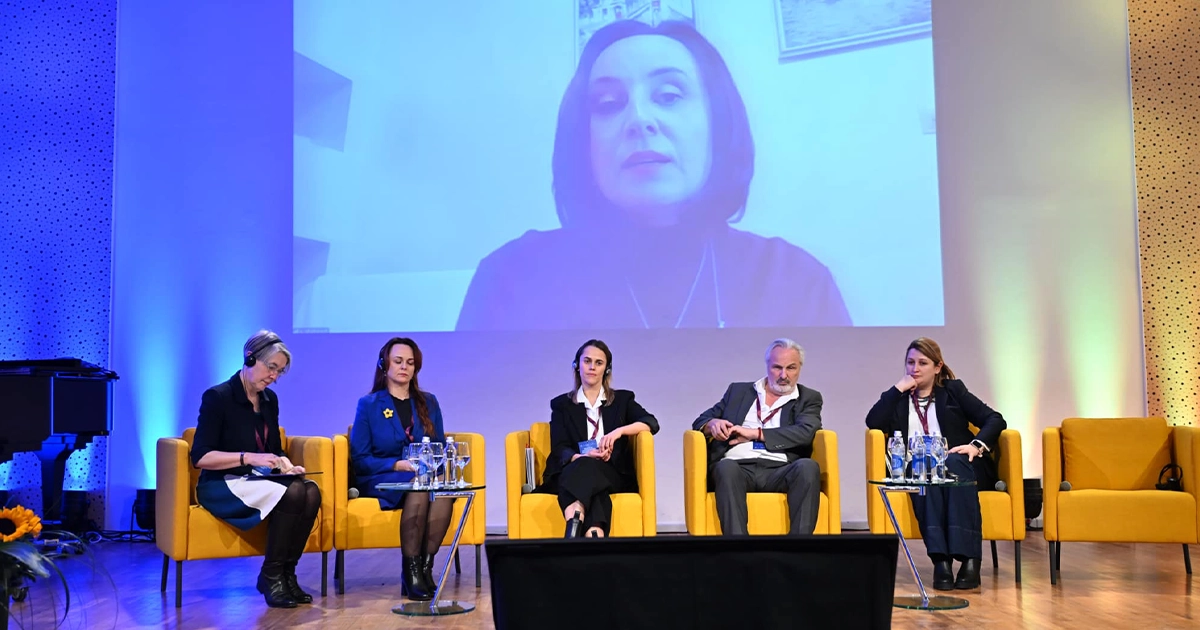 Дитина з українським прапором у руках дивиться на дорогу