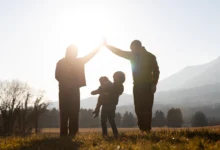 Християнська родина тримається за руки в полі