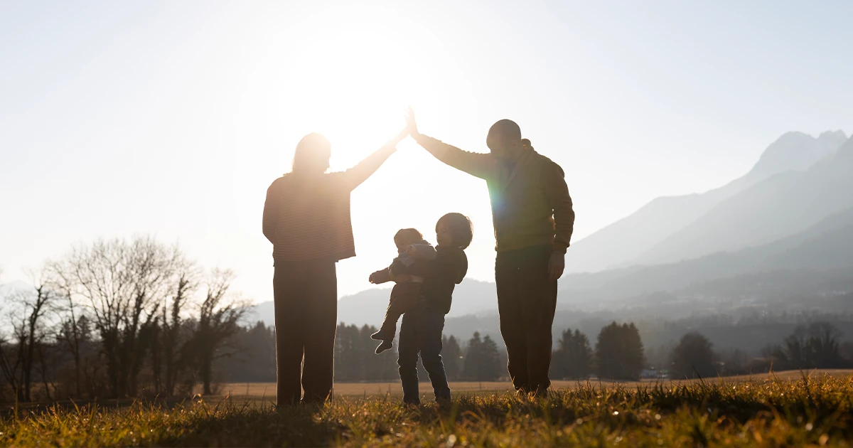 Християнська родина тримається за руки в полі