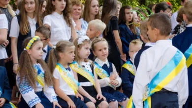 Дитина з рюкзаком, яку фотографують на шкільному подвір’ї