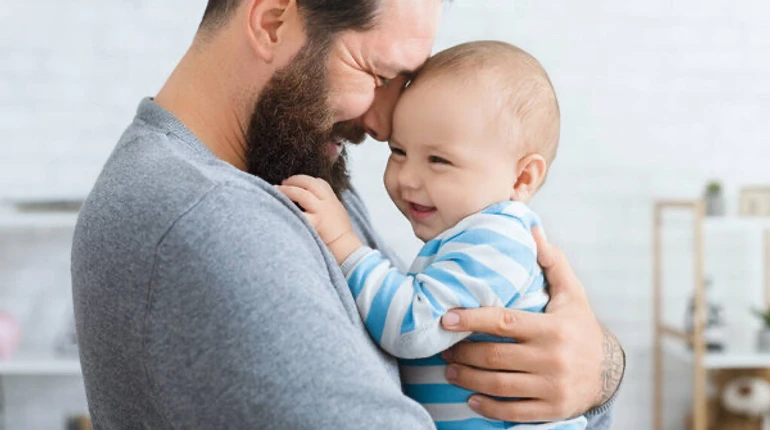 Тато проводить час із новонародженою дитиною вдома
